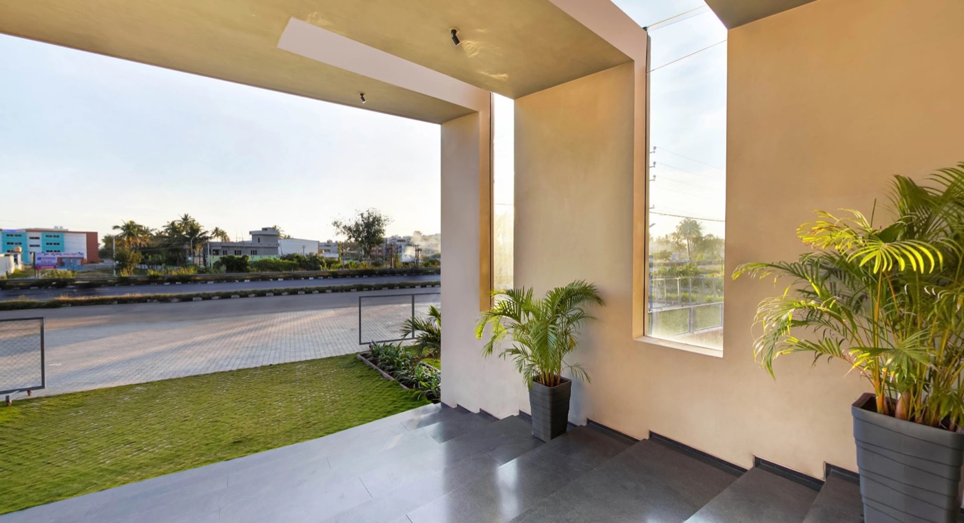 A sunlit terrace inside the PU building with plants and a lawn